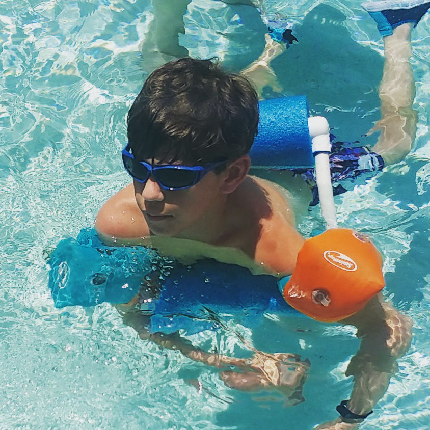 image of boy swimming with adapated swim float
